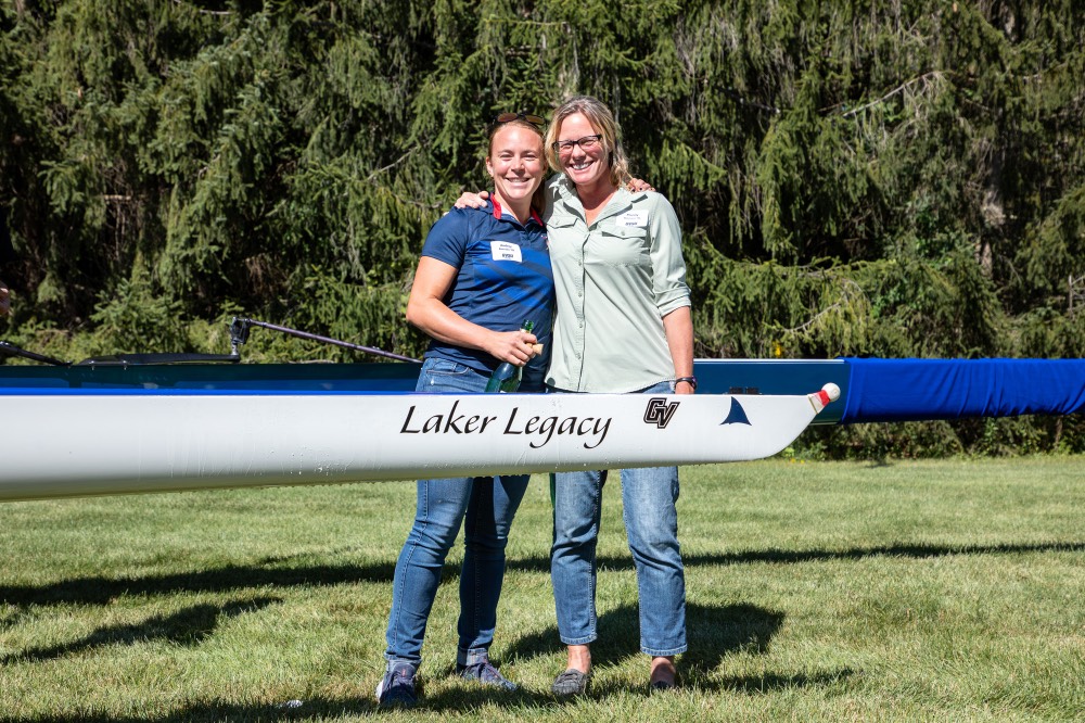 GVSU mother and daughter alumni Mandy Boersen and Audrey Boersen hugging behind boat that says Laker Legacy